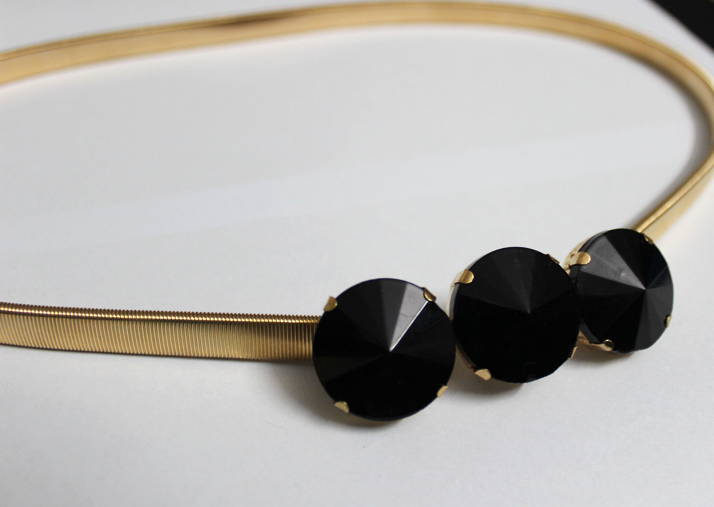 Golden belt with black stones