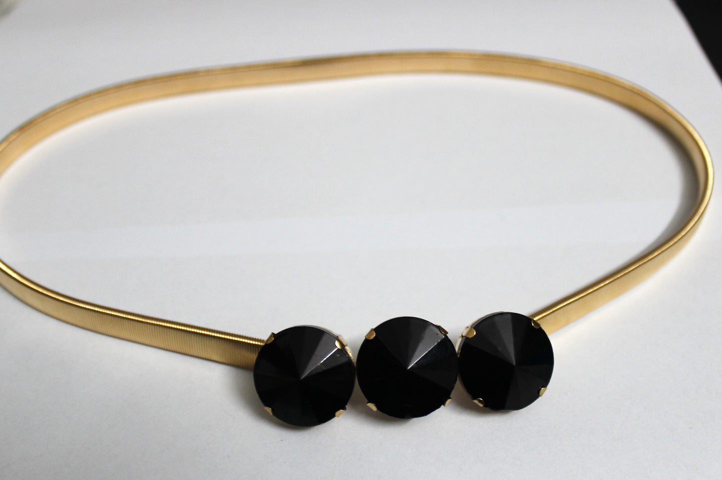 Golden belt with black stones